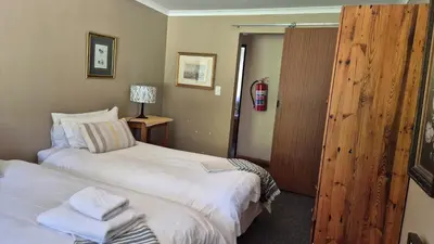 a hotel room with two beds with towels on them at Apple Blossom Cottage in Dullstroom