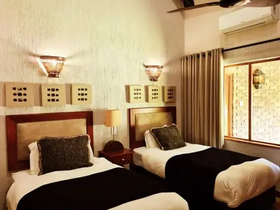 a hotel room with two beds and a window at Kruger Park Lodge Unit No. 267 with private pool in Hazyview