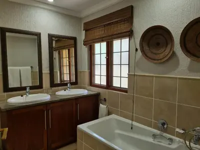 a bathroom with two sinks and two mirrors at Kruger Park Lodge Unit No. 267 with private pool in Hazyview