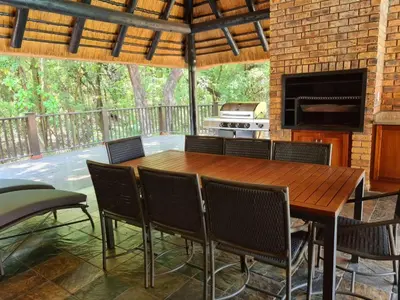 a wooden table and chairs on a patio at Kruger Park Lodge Unit No. 267 with private pool in Hazyview