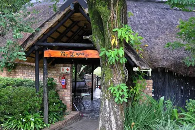 a sign on a tree in front of a building at Kruger Park Lodge Unit No. 267 with private pool in Hazyview
