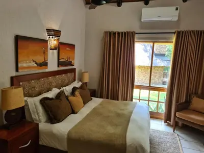 a bedroom with a large bed and a window at Kruger Park Lodge Unit No. 267 with private pool in Hazyview