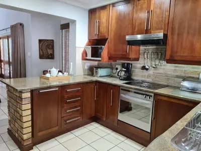 a kitchen with wooden cabinets and a stove top oven at Kruger Park Lodge Unit No. 267 with private pool in Hazyview