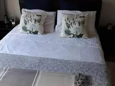 a white bed with white sheets and pillows at Kanimambo Chalet in Marloth Park