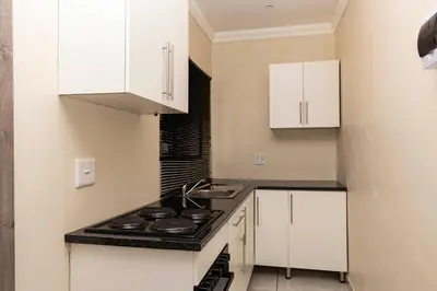 a kitchen with white cabinets and a stove at Mandulia Guest House in Nelspruit