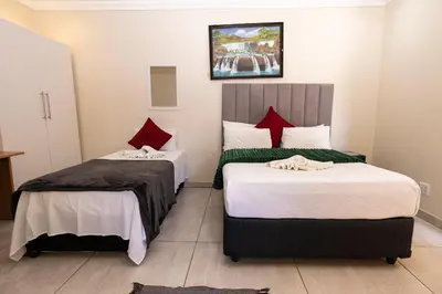a hotel room with two beds with red pillows at Mandulia Guest House in Nelspruit