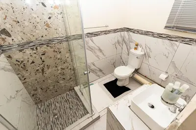 a bathroom with a shower and a toilet and a sink at Mandulia Guest House in Nelspruit