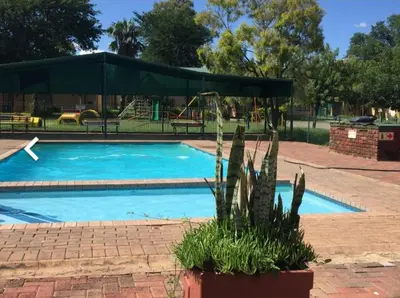 a swimming pool with a tent and a playground at Pendleberry Holiday Resort - Unit 40 in Bela-Bela