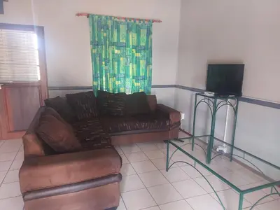 a living room with a couch and a television at Pendleberry Holiday Resort - Unit 40 in Bela-Bela