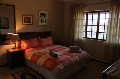 a bedroom with a bed with a hat and a window at Phil's Place in Dullstroom