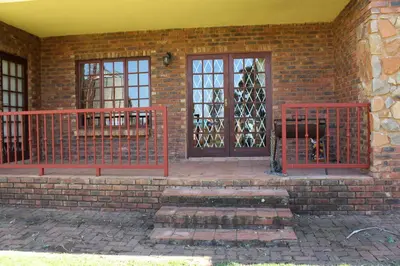 a red gate in front of a brick building at Phil's Place in Dullstroom