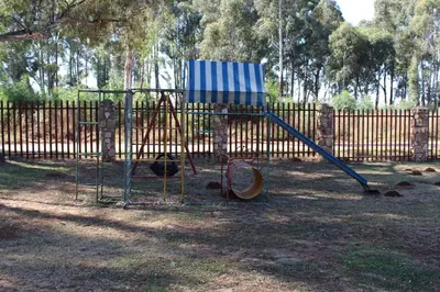 a playground in a park with a wooden fence at Phil's Place in Dullstroom