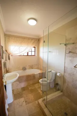 a bathroom with a tub and a toilet and a sink at Phil's Place in Dullstroom