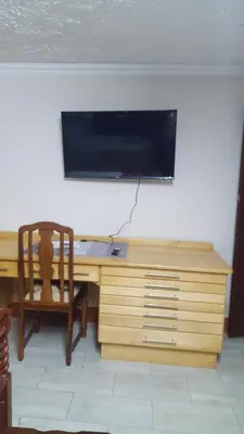 a wooden desk with a television on a wall at Julie's B&B in White River
