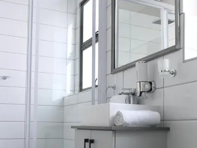 a bathroom with a sink and a mirror at Next To Apartment Hotel in Pretoria