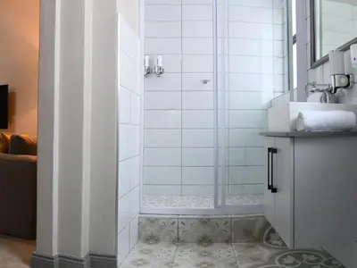 a shower with a glass door in a bathroom at Next To Apartment Hotel in Pretoria
