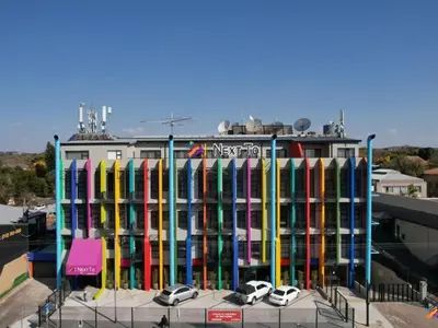 a colorful building with cars parked in front of it at Next To Apartment Hotel in Pretoria