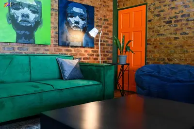 a living room with a green couch and a orange door at Next To Apartment Hotel in Pretoria