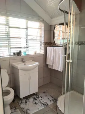 a bathroom with a sink toilet and a shower at Menlyn Mews Guesthouse in Pretoria