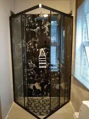 a shower with a black and white wall at Menlyn Mews Guesthouse in Pretoria