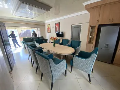 a dining room with a table and blue chairs at Menlyn Mews Guesthouse in Pretoria