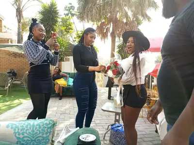 three women standing next to each other holding a bouquet of flowers at Menlyn Mews Guesthouse in Pretoria