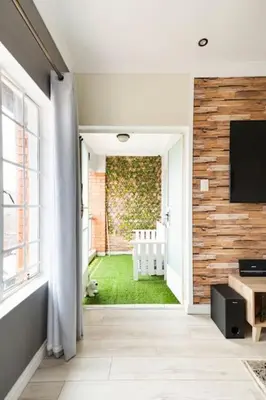 a hallway with a television and a room with a lawn at Sunset View Apartment with Free Secure Parking in Central Location in Centurion