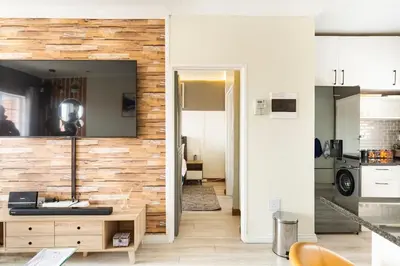 a living room with a large mirror on a wall at Sunset View Apartment with Free Secure Parking in Central Location in Centurion