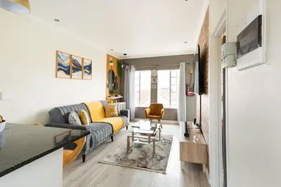 a living room with a couch and a table at Sunset View Apartment with Free Secure Parking in Central Location in Centurion