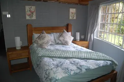 a bedroom with a bed and two nightstands and a window at Nita's Air Bed & Breakfast & self catering in Crocodile Valley Estates