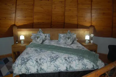 a bedroom with a large bed with two lights on it at Nita's Air Bed & Breakfast & self catering in Crocodile Valley Estates