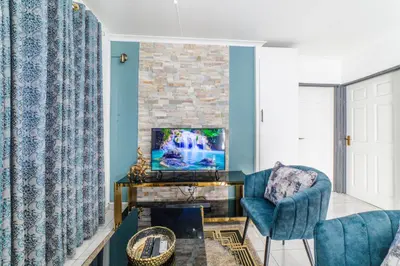a living room with a tv and a chair at Homes of Ace Gold in Pretoria