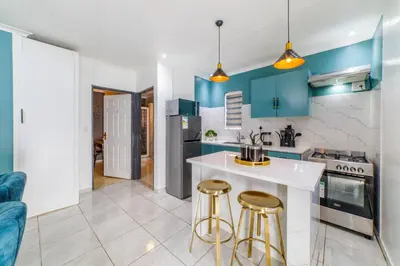 a kitchen with blue cabinets and a white counter top at Homes of Ace Gold in Pretoria
