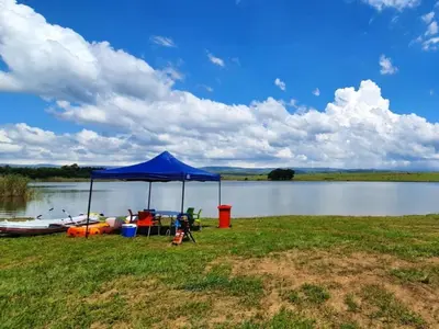 a blue tent on the side of a lake at Sunrise Serenity Guest House in Lydenburg