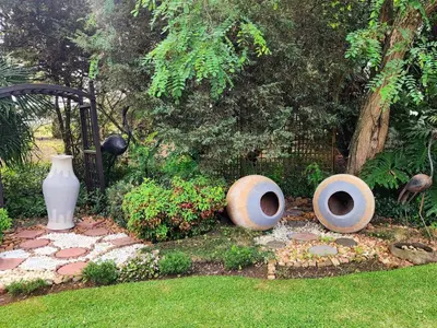a garden with two large concrete vases on the grass at Sunrise Serenity Guest House in Lydenburg