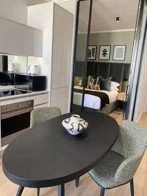 a black table with two chairs and a bedroom at Executive Apartment at Ellipse Waterfall in Midrand