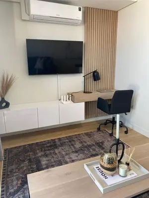 a living room with a tv and a chair at Executive Apartment at Ellipse Waterfall in Midrand