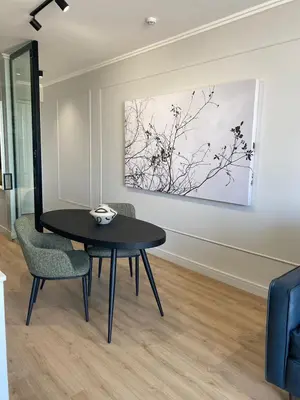 a dining room with a table and chairs and a painting at Executive Apartment at Ellipse Waterfall in Midrand
