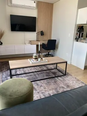 a living room with a coffee table and a chair at Executive Apartment at Ellipse Waterfall in Midrand