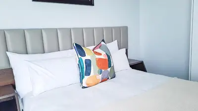 a bed with two pillows on top of it at Executive Apartment at Ellipse Waterfall in Midrand