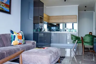 a living room with a couch and a kitchen at Executive Apartment at Ellipse Waterfall in Midrand
