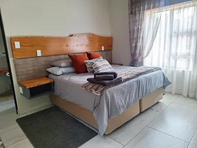 a bed with a wooden headboard in a bedroom at The Hank Maribashoek Adventure Lodge in Mokopane