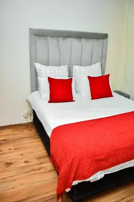a large bed with two red pillows on it at MTH in Nelspruit