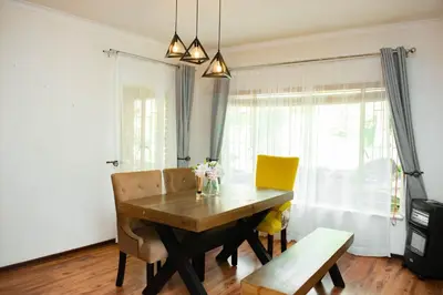 a dining room with a wooden table and chairs at MTH in Nelspruit
