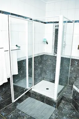 a shower with a glass door in a bathroom at MTH in Nelspruit