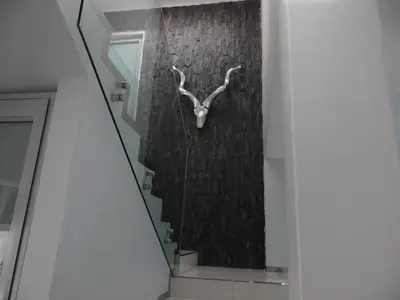 a stairway with a sculpture of a deer on the wall at Augusta Palms - White Room in Centurion