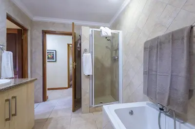 a bathroom with a shower and a bath tub at Kruger Park Lodge Unit No. 547 in Hazyview