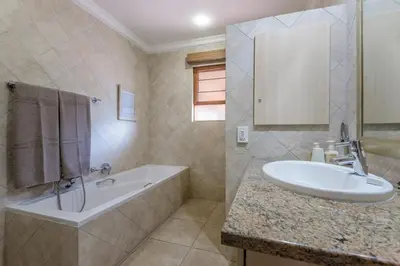 a bathroom with a sink and a bath tub and a sink at Kruger Park Lodge Unit No. 547 in Hazyview