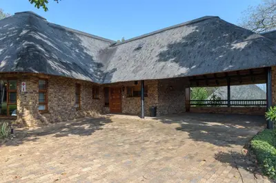 a large stone house with a thatched roof at Kruger Park Lodge Unit No. 547 in Hazyview