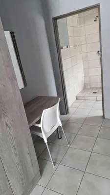a bathroom with a table and a chair and a shower at The Unit Party House in eNyalungu